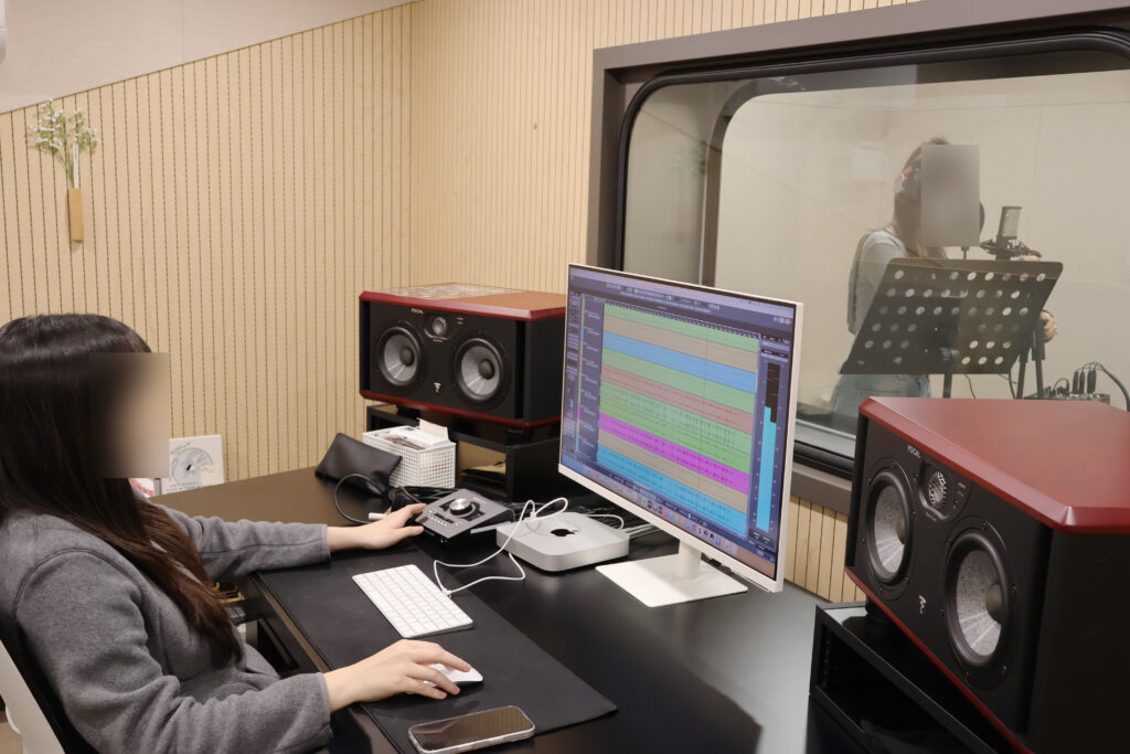 보컬 학원에서 마이크를 사용해 노래를 연습하는 수강생