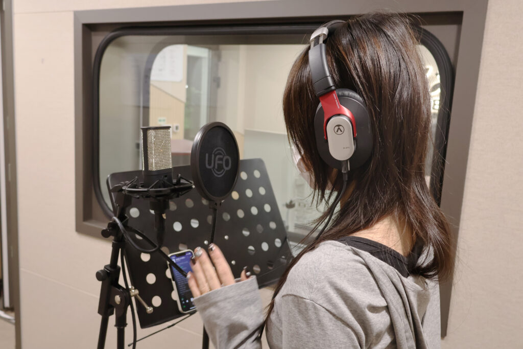 보컬 학원에서 마이크를 사용해 노래를 연습하는 수강생